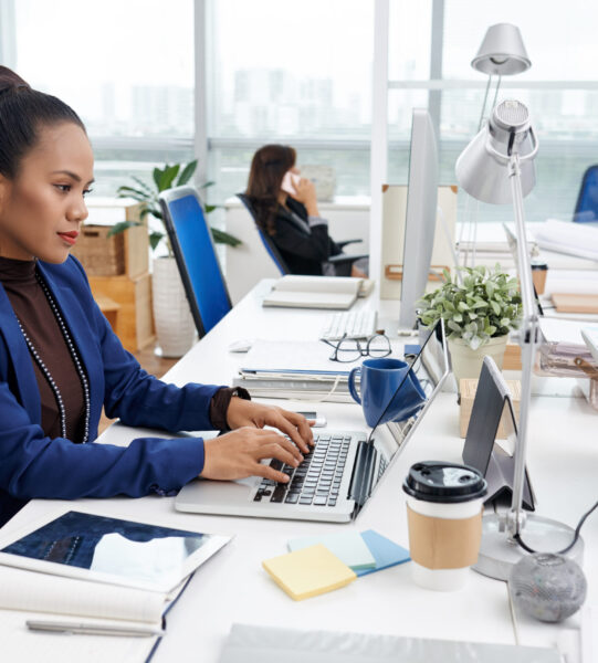 Pretty Asian business woman working on laptop at her table
